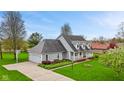 Spacious home with an attached garage and long driveway, surrounded by a beautifully landscaped yard and mature trees at 5341 W Stonehaven Ln, New Palestine, IN 46163