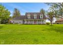 Charming gray two-story home with a welcoming front porch, well-manicured lawn, and landscaped garden at 5341 W Stonehaven Ln, New Palestine, IN 46163