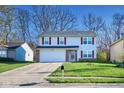 Traditional two-story home with attached garage and a green lawn in a suburban neighborhood at 5424 Milhouse Rd, Indianapolis, IN 46221