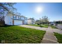 Two-story home with an attached garage, located on a lot with a well-manicured lawn at 5424 Milhouse Rd, Indianapolis, IN 46221