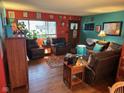 Inviting living room featuring hardwood floors, ample seating, and vibrant, colorful decor at 5626 Hammon Dr, Brownsburg, IN 46112