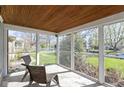 Relaxing screened front porch offering a view of the landscaped front yard at 6164 Evanston Ave, Indianapolis, IN 46220