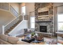 Inviting living room features a stone fireplace, staircase, and comfortable seating, perfect for relaxing and entertaining at 6702 Thresher Pass, McCordsville, IN 46055