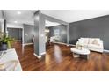 Expansive open-concept living space with hardwood floors, gray walls, plus seamless transition into the dining area at 7128 English Oak Dr, McCordsville, IN 46055