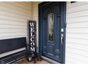Elegant front door with decorative glass, complemented by a bench and a welcoming 'Welcome' sign at 8231 N Chaucer Ct, Columbus, IN 47201