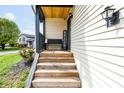 Inviting front porch with wooden steps, a bench, and a 'Welcome' sign, creating a warm entrance at 8231 N Chaucer Ct, Columbus, IN 47201
