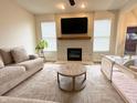 Cozy living room featuring a stone fireplace, large windows, and comfortable neutral-toned seating at 8333 Sansa St, Indianapolis, IN 46113