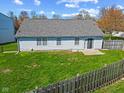 Fenced backyard with lush lawn, offers a private outdoor space for relaxation and recreation at 84 Beech Ct, Whiteland, IN 46184