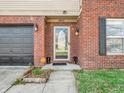 Close up of a charming brick home's front entrance, featuring a glass door and well-maintained landscaping at 8813 Browns Valley Ln, Indianapolis, IN 46113