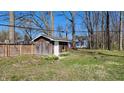 Wooden shed in a fenced backyard with daffodil landscaping and mature trees at 9882 Woodbriar Ln, Carmel, IN 46280