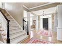 Grand foyer with staircase, hardwood floors, and columns, offering a view into the dining area at 10846 Hamilton Pass, Fishers, IN 46037