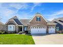Inviting brick home featuring a well-manicured lawn and a spacious three-car garage, set under a bright, blue sky at 11685 Platt St, Noblesville, IN 46060