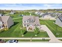 Aerial view of a well-manicured lawn and landscaping in a residential community with a pond at 12894 Corydon Dr, Fishers, IN 46037