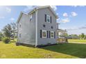 Two-story home features gray siding, black shutters, and a well-maintained lawn at 13 N Main St, Brooklyn, IN 46111