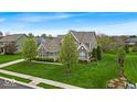 Landscaped lawn surrounds this beautiful two-story home on a sunny day at 1533 Windswept, Brownsburg, IN 46112