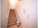 Bright stairway with carpeted steps, accessible chairlift, and a secure white door at 1575 Sierra Springs, Carmel, IN 46280