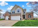 Beautiful two-story house with brick accents, attached garages, and landscaped front yard at 15890 Concert Way, Noblesville, IN 46060