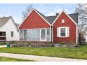 A cozy red home with a unique stone-bordered flower bed adding charm to the front yard at 1646 Fisher Ave, Indianapolis, IN 46224