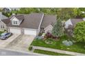 Aerial view of brick home with attached garage and landscaped lawn, complemented by mature trees at 17777 Crown Pointe Ct, Noblesville, IN 46062