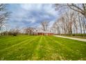Spacious red brick home set back on a large lawn, offering privacy and curb appeal at 1911 N Rangeline Rd, Anderson, IN 46012