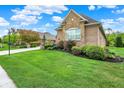 Beautiful front lawn with lush green grass and manicured bushes surrounding a brick home at 2507 Silver Oaks Dr, Carmel, IN 46032