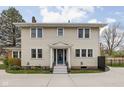 Inviting two-story home featuring vinyl siding, a charming front entrance, and a well-maintained lawn at 310 W 43Rd St, Indianapolis, IN 46208