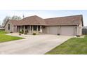 Lovely brick home with an attached three car garage and an expansive driveway and well-kept lawn at 3300 E Indian Hill Dr, Muncie, IN 47302