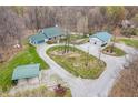Aerial view displays a house with well-maintained grounds, outbuildings, and a circular gravel driveway at 3504 Morgan Oaks Cir, Martinsville, IN 46151