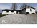 Single-story home with white brick, black shutters, and a gravel driveway at 3689 S County Road 800 W, Coatesville, IN 46121