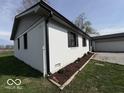 Side view of a white brick home with landscaped flower beds at 3689 S County Road 800 W, Coatesville, IN 46121