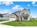 Inviting two-story home with green lawn, two-car garage, stone accents, and a manicured front yard at 4087 Railhead Ave, Westfield, IN 46074