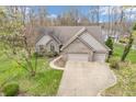Stunning aerial view of a brick home with two car garage and mature trees at 454 Roberson Blvd, Mooresville, IN 46158