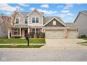 Beautiful two-story home featuring a three-car garage, brick accents, and a well-maintained lawn at 5374 Marigold Dr, Plainfield, IN 46168
