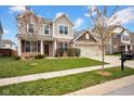 Inviting two-story home with a three-car garage, brick details, green lawn, and attractive landscaping at 5374 Marigold Dr, Plainfield, IN 46168