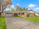 Beautiful brick home featuring an attached two-car garage, lush green lawn, and driveway at 5420 E 81St St, Indianapolis, IN 46250