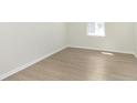 A serene bedroom featuring hardwood floors, ample natural light, and neutral color palette with simple, elegant trim at 5804 Summertree Pl, Whitestown, IN 46052