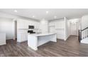Modern white kitchen featuring a large island, stainless steel appliances, and hardwood floors at 5804 Summertree Pl, Whitestown, IN 46052