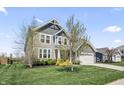 Two-story home with lush lawn, gray siding, complementing the attached two-car garage at 6472 W Treeline Ln, McCordsville, IN 46055