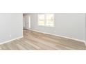 Bright living room features new wood floors, modern paint, and plenty of natural light from the large window at 718 Marie Ln, Fortville, IN 46040