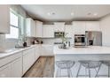 Bright kitchen with white cabinets, a center island with seating, and stainless steel appliances at 7337 Deerberg Dr, Indianapolis, IN 46259