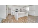 Modern white kitchen with a center island, stainless steel appliances, and wood-look flooring at 827 Allandale Ave, Westfield, IN 46074