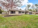Beautifully landscaped yard with a single-story home featuring a stone facade and a two-car garage at 8621 Manderley Dr, Indianapolis, IN 46240