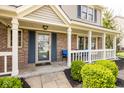 Inviting front porch with white railing, brick pillars, and a cozy seating area, creating a welcoming entrance at 9812 Logan Ln, Fishers, IN 46037