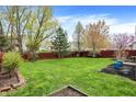 Spacious backyard featuring a lush lawn, mature trees, and a classic wooden fence, creating a serene outdoor space at 10485 Alderwood Ct, Fishers, IN 46038