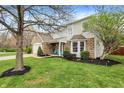A lovely home with brick and siding, a well-maintained lawn, and a welcoming front porch with blue chairs at 10485 Alderwood Ct, Fishers, IN 46038