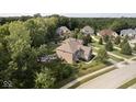Expansive aerial view showcases a large home with a private backyard, fire pit, play area, and mature trees at 1060 Cape Coral Dr, Cicero, IN 46034