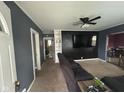 Cozy living room with a dark accent wall and neutral carpet, and an open door to a bathroom at 1150 Younce St, Franklin, IN 46131