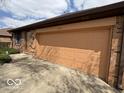 Close up on the brick exterior and garage door with address posted above at 1215 Willow Springs Blvd, Brownsburg, IN 46112