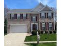 Charming brick two-story home with a two car garage, manicured lawn, and dark shutters at 12561 Gladecrest Dr, Carmel, IN 46033