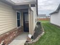 Protected front entrance with manicured landscaping and secure yard at 1302 Lexington Trl, Greenfield, IN 46140